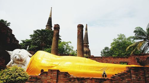 View of buddha statue against trees and buildings