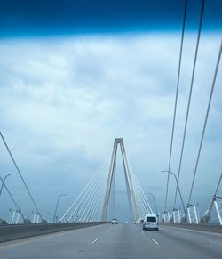 View of suspension bridge against cloudy sky