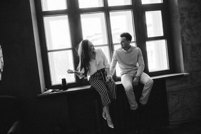 Young couple sitting on window