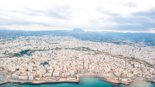 Aerial view of city against cloudy sky