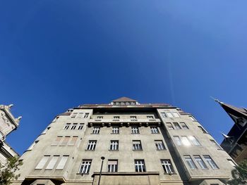 Low angle view of buildings against clear blue sky