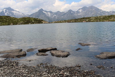 Scenic view of lake by mountains against sky