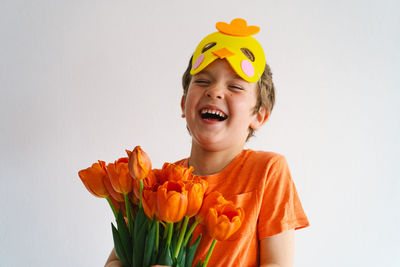 Cheerful boy laughing against white background