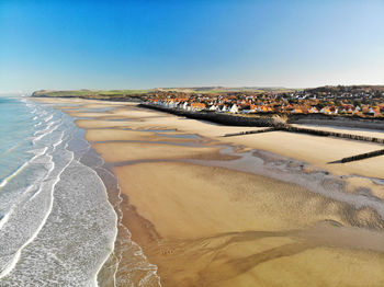 Scenic view of beach against clear blue sky