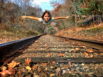 Portrait of young woman on railroad track