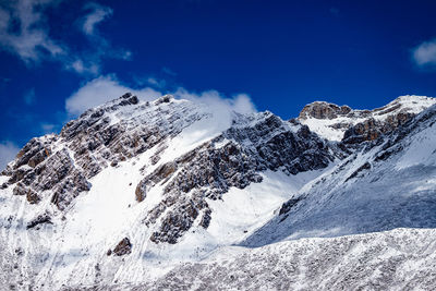 Scenic view of snowcapped mountains against blue sky