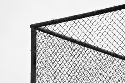 Low angle view of chainlink fence against sky