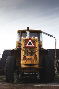 Old wheel loader in yellow from 1960s viewed from the back