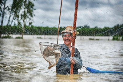 Portrait of woman with umbrella on wet shore