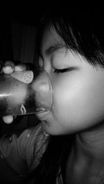 Close-up portrait of cute girl drinking water