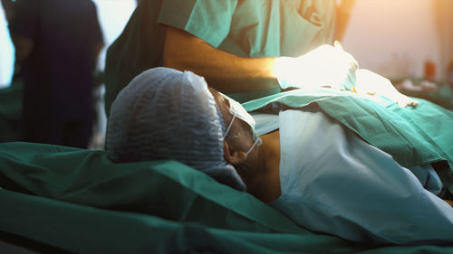 Low section of woman relaxing on bed at home
