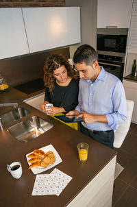 Young woman using smart phone while sitting on table