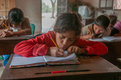 High angle view of girl and book on table