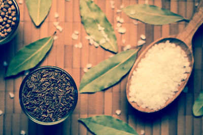 Directly above shot of bay leaves with cumin and salt on table