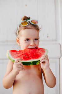 Portrait of cute boy eating fruit