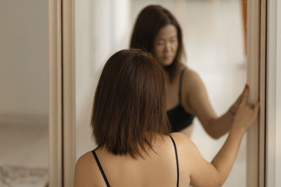 Side view of young woman looking away at home