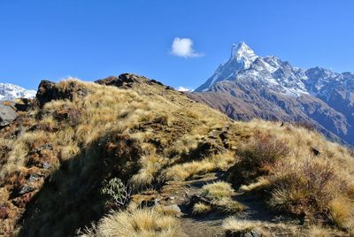 Scenic view of snowcapped mountains against blue sky