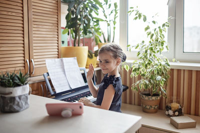 Woman sitting on table at home