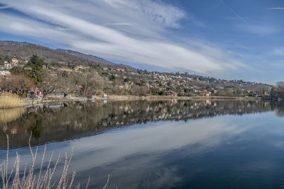 Scenic view of lake by buildings against sky