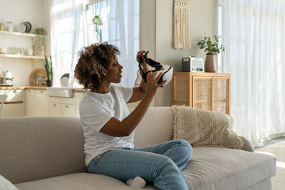 Young woman using phone while sitting at home