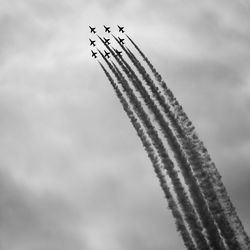 Low angle view of airplanes flying against sky