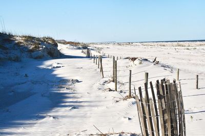 Scenic view of snow covered beach against clear sky
