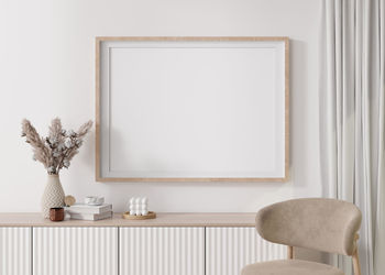 Empty horizontal picture frame on white wall in modern living room. mock up interior 