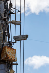 Two old cctv security surveillance cameras on street light pole on blue sky background