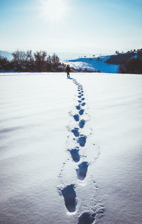 Scenic view of snow covered field against sky