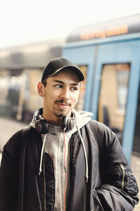 Thoughtful male university student standing at subway station