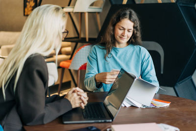 Portrait of woman using laptop while sitting on table