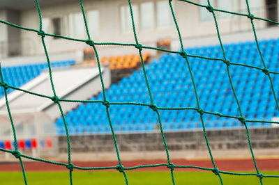 Close-up of soccer field seen through goal post net