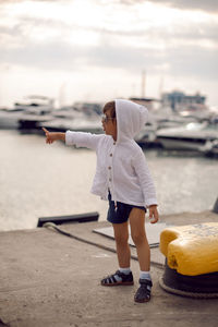 Boy child traveler stand on the marina with yachts in sochi in the summer