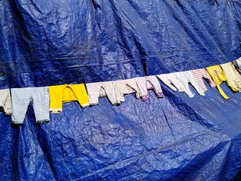 Close-up of clothes drying against blue wall