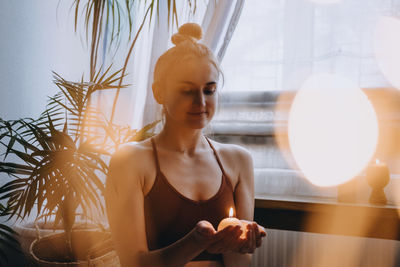 Young woman looking through glass window