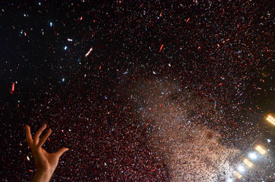 Low angle view of hands against star field at night