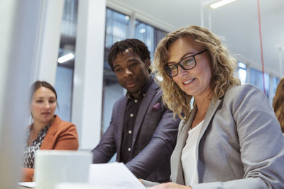 Multi-ethnic colleagues working at desk in office