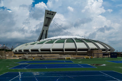 View of gazebo by building against cloudy sky