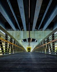 Empty walkway below bridge