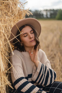 Portrait of young woman wearing hat on field