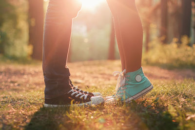 Low section of couple standing on field