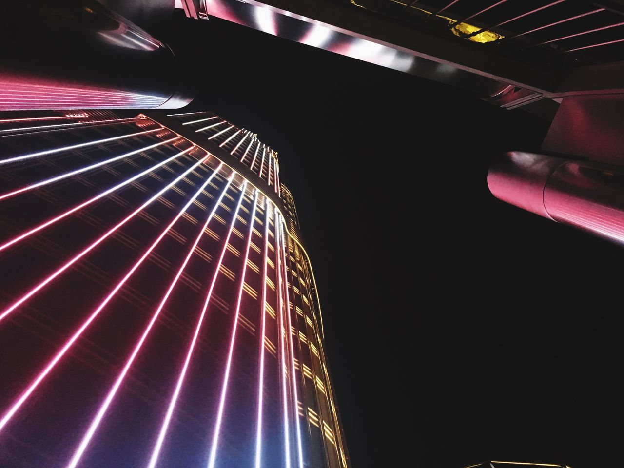 LOW ANGLE VIEW OF ILLUMINATED LIGHT TRAILS IN CITY AGAINST SKY