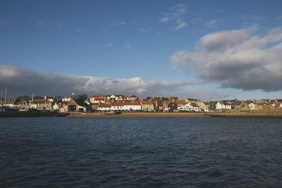 Scenic view of sea by buildings against sky