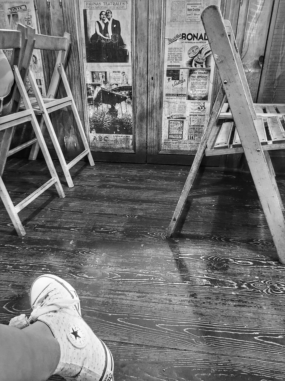 LOW SECTION OF PERSON STANDING ON WOODEN FLOOR IN ROOM