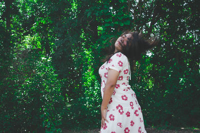 Midsection of woman standing by tree