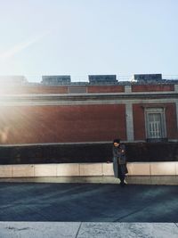 Man walking on street against building in city