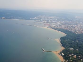 Aerial view of cityscape and sea against sky