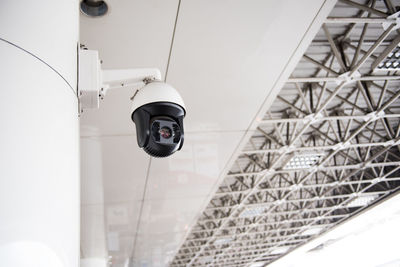Low angle view of security camera on wall