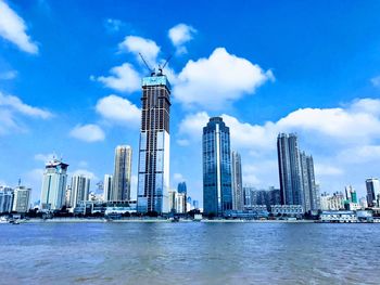 Modern buildings in city against cloudy sky