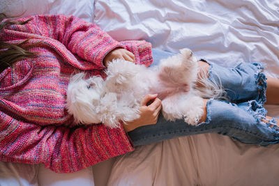 Woman with dog on bed at home